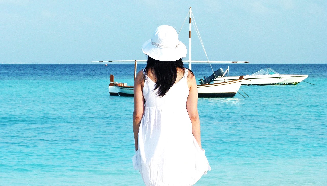 海辺に佇む白い帽子（ホワイトハット）の女性